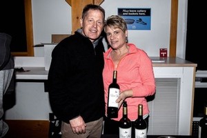 People posing holding a River Stone Estate Wine bottle