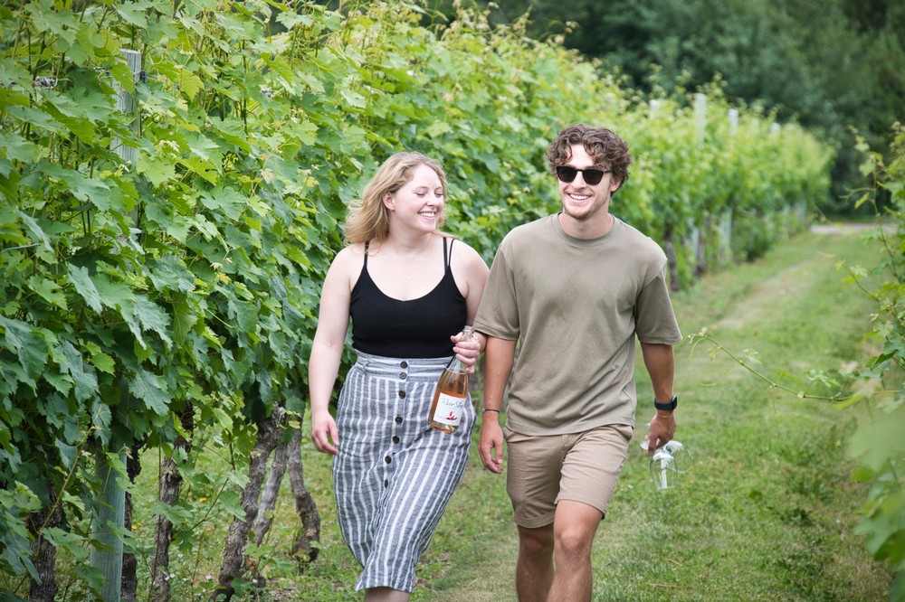 Two people walking through River Stone Estate Vineyard