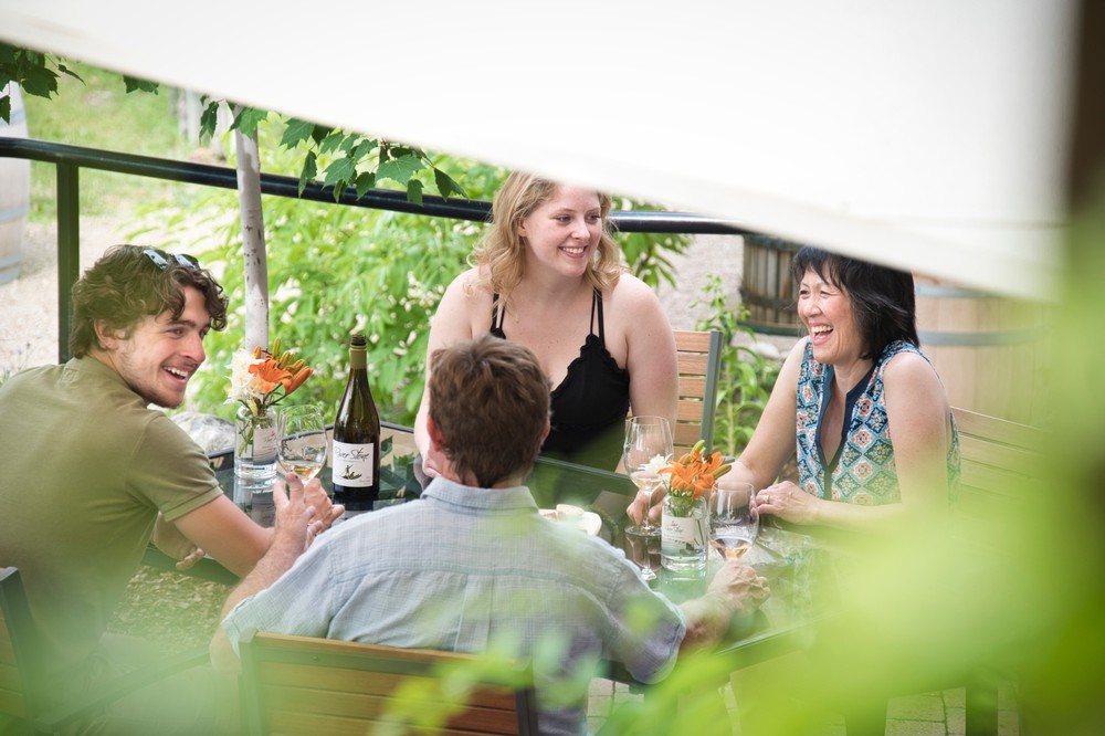 Group of people enjoying River Stone wine outside on a patio