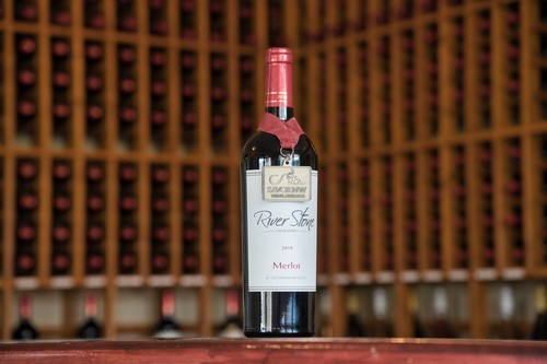 River Stone Wine bottle one wooden counter 