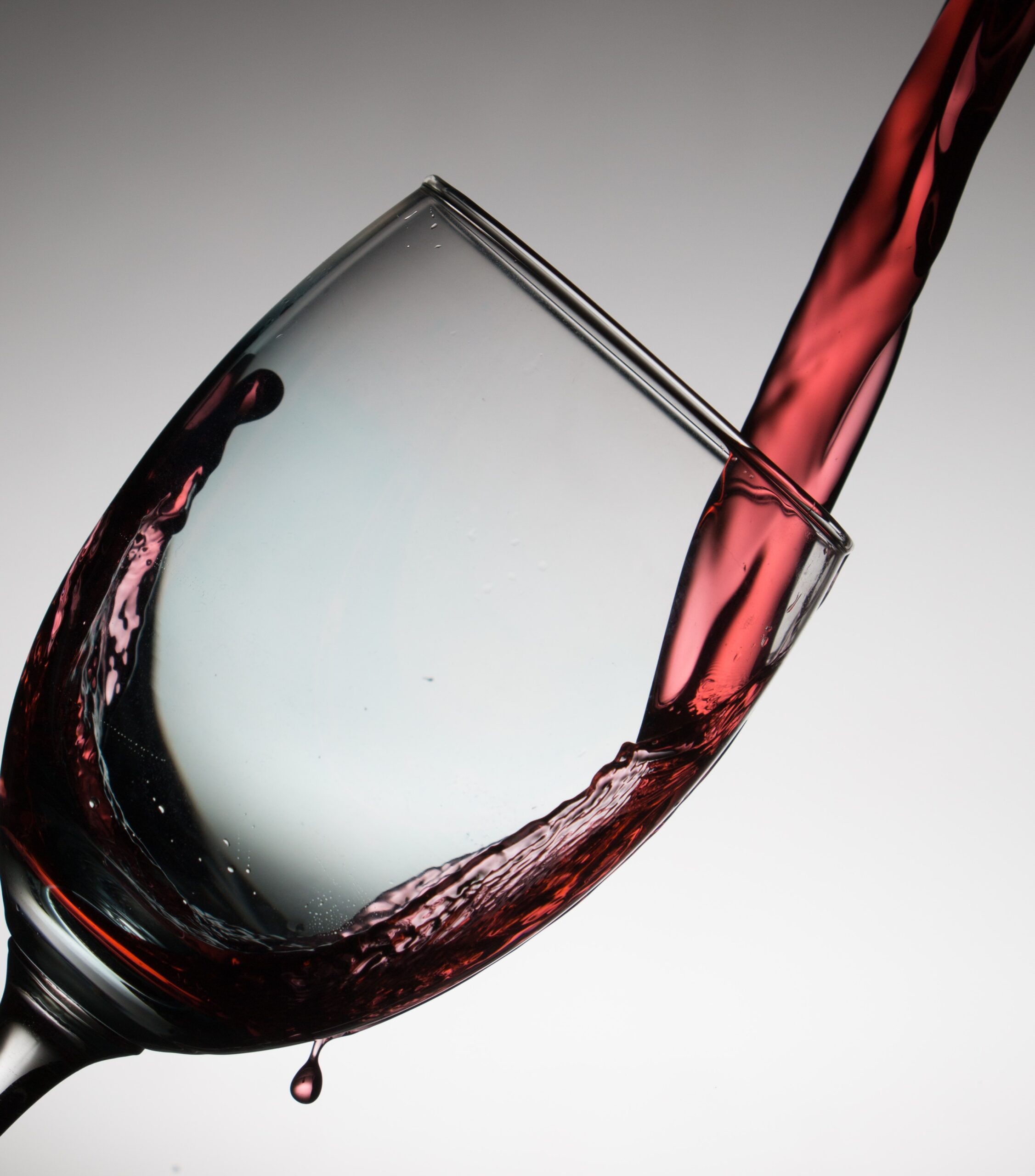 close up of wine being poured into a wine glass